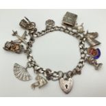 A vintage silver curb chain charm bracket with padlock clasp, safety chain and 11 silver charms.