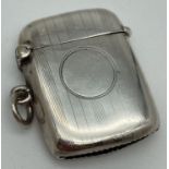 An early 20th century silver vesta case with engine turned detail and circular empty cartouche.