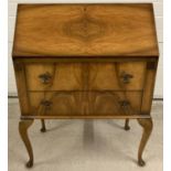 A vintage walnut veneer 2 drawer bureau, raised on cabriole legs. With interior stationary