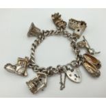A vintage silver charm bracelet with padlock clasp, safety chain and 7 silver and white metal