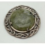 A vintage Celtic pierced work brooch set with a round green agate stone. Silver marks to reverse.