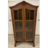 A vintage dark wood, glass fronted display cabinet, complete with key. Shaped top with carved detail