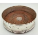 A hallmarked silver wine coaster with wooden base and green baize underside. Fully hallmarked John