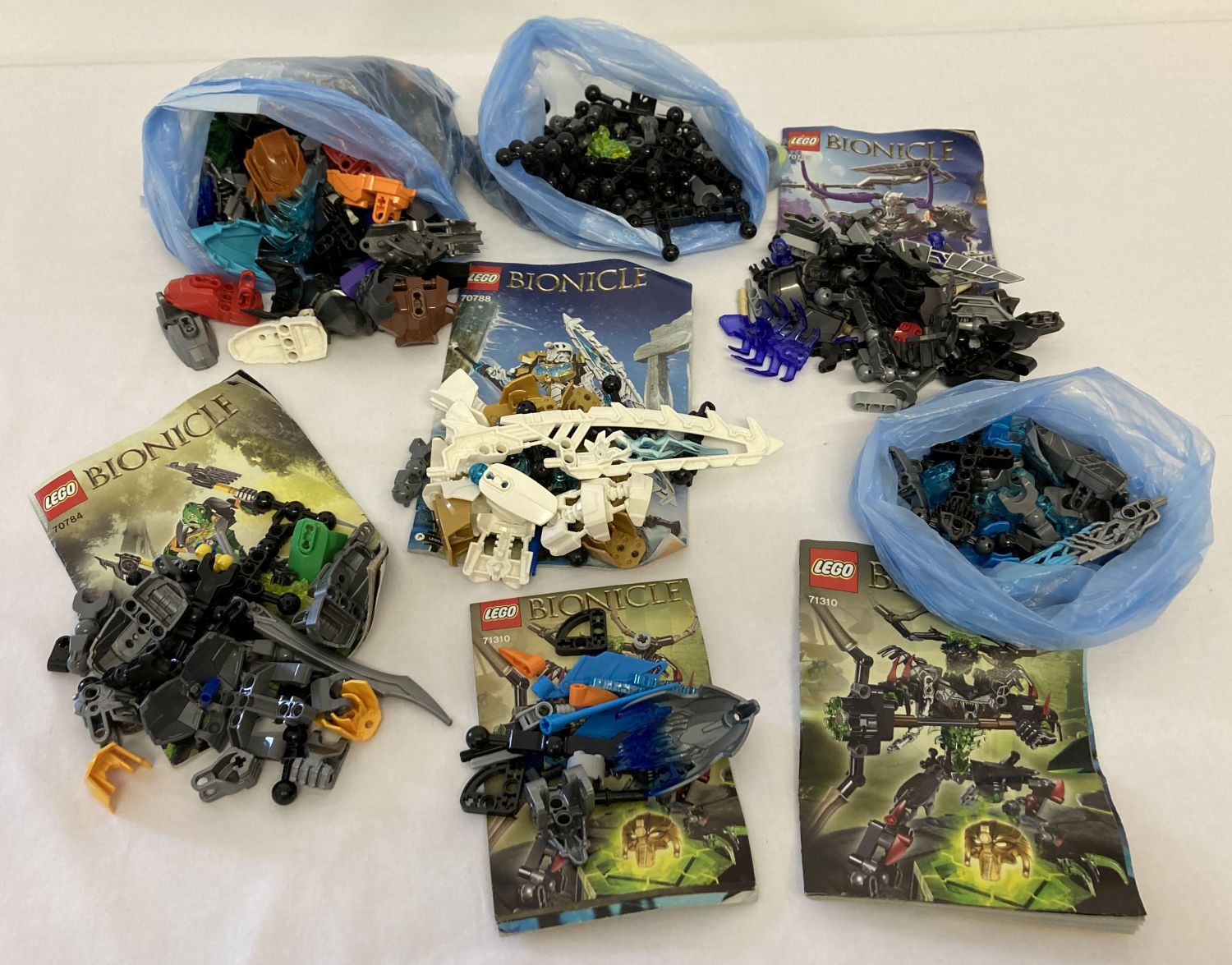 A collection of assorted Lego Bionicle play pieces and instructions.