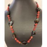 A 19" costume jewellery necklace made from disc shaped coral beads and polished onyx beads.