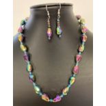 A faceted iridescent lustre glass beaded necklace with matching drop earrings.