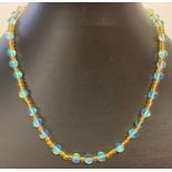 A 15" yellow glass and turquoise Austrian crystal beaded necklace with gold tone magnetic clasp.