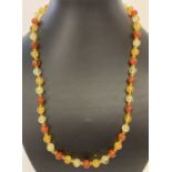 A 22" three coloured faux amber beaded necklace with gold tone T bar clasp.