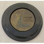 A replica military bronze medallion, mounted in wooden circular wall hanging frame.