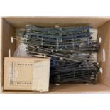 A box of vintage 3 rail O gauge model railway track in varying lengths.
