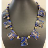 A boxed lapis Lazuli and gold tone bead Cleopatra style necklace with gold tone S shaped clasp.