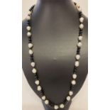 A 25" large freshwater pearl and onyx beaded necklace with silver tone S shaped hook clasp.