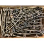 A box of assorted vintage O gauge model railway track and points.
