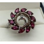 A modern design silver dress ring in the design of a peacock set with 10 marquise cut rhodolite g…