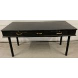 A large painted black wooden desk/buffet table with 2 drawers and pull out rests. Brass handles t…