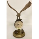 An ornamental brass ball clock with eagle shaped finial and rabbit figures to base. Wind up mecha…