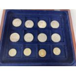 A wooden coin display box with blue baize lined interior & contents. Contents comprise 8 x commem…