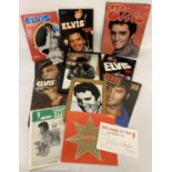 A collection of assorted Elvis Presley collectable memorabilia. To include books, framed mirrors …
