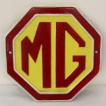 A painted cast iron octagonal shaped MG wall plaque. In red, yellow and white and complete with …