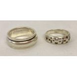 2 silver band style rings. A spinner ring together with a band with pierced crosses and stars de…