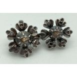 A vintage double flower design white gold brooch set with diamond chips. Tests as 14ct. Each