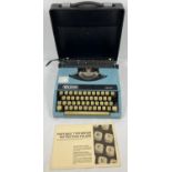 A vintage Wilding TW100 portable typewriter with hard carry case and instruction manual.