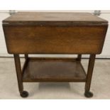 A vintage dark wood drop leaf tea trolley with under shelf. Approx. 69cm tall x 66cm wide.