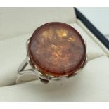 A modern design silver and amber dress ring by The Genuine Gem Company. A cabochon of amber in a