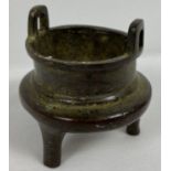 A miniature Chinese bronze censer with loop handles and raised on tapered tripod legs. Impressed