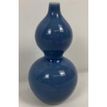 A small Chinese ceramic bottle gourd shaped bud vase with blue glaze. Signature marks to