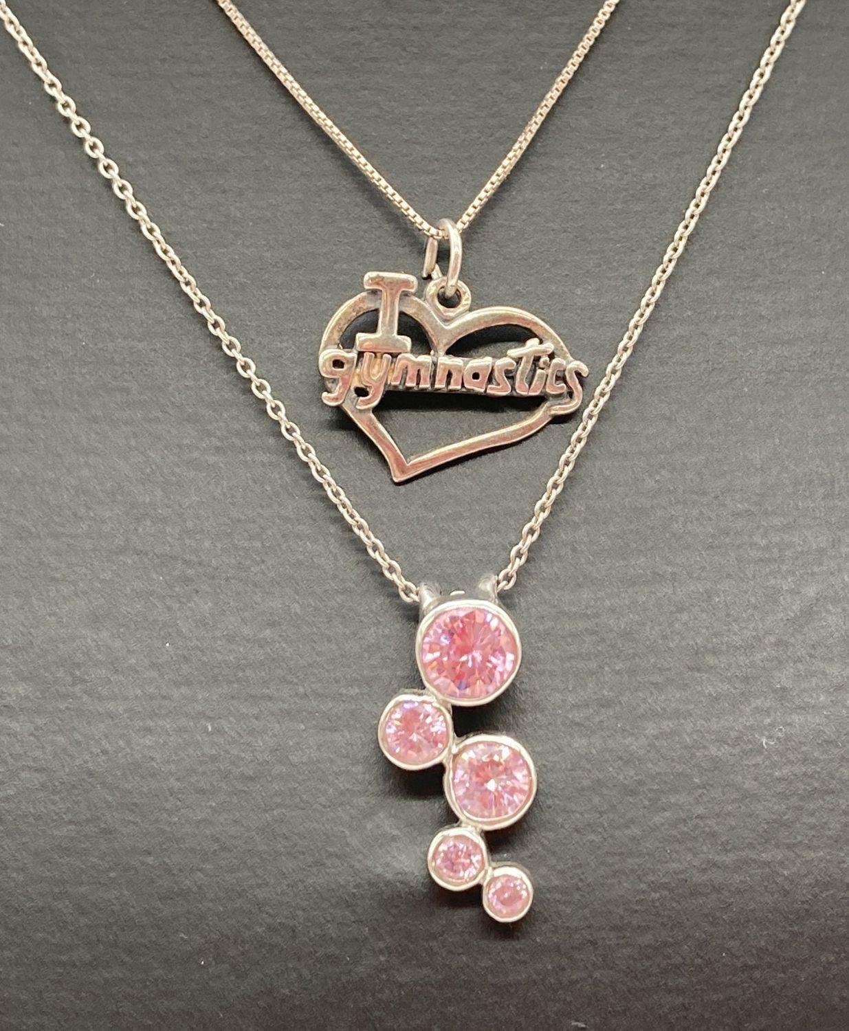 2 silver pendant necklaces. A modern design pendant set with 5 round cut pink stones on an 18 inch