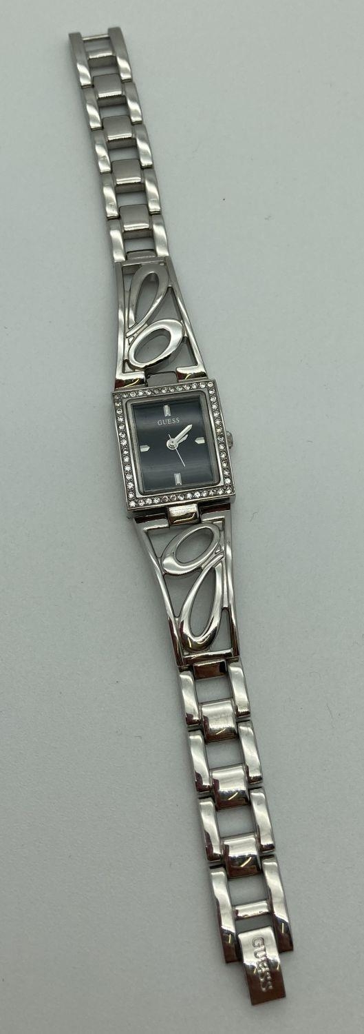 A ladies stainless steel bracelet wristwatch by Guess. Square case set with small crystals. Black