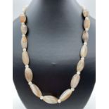 A 21" agate and mother of pearl beaded necklace, with white metal T bar clasp. Ex jewellery makers