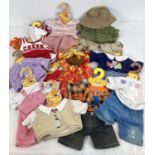 A collection of 11 Build-a-bear and Bear factory outfits and coat hangers.