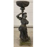 An antique metal garden ornamental figure of a lady in classical dress on stepped base.