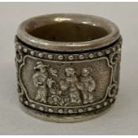 A Chinese white metal archers ring with figural detail on central rotating panel.