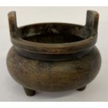 A Chinese bronze 3 footed censer with loop handles and impressed marks to underside.
