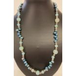 A 22" peacock blue freshwater pearl and aquamarine beaded necklace with white metal spacer beads.