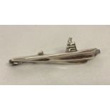 A white metal tie clip in the shape of a submarine.