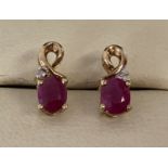 A pair of 9ct gold ruby and diamond stud style earrings with gold twist design.