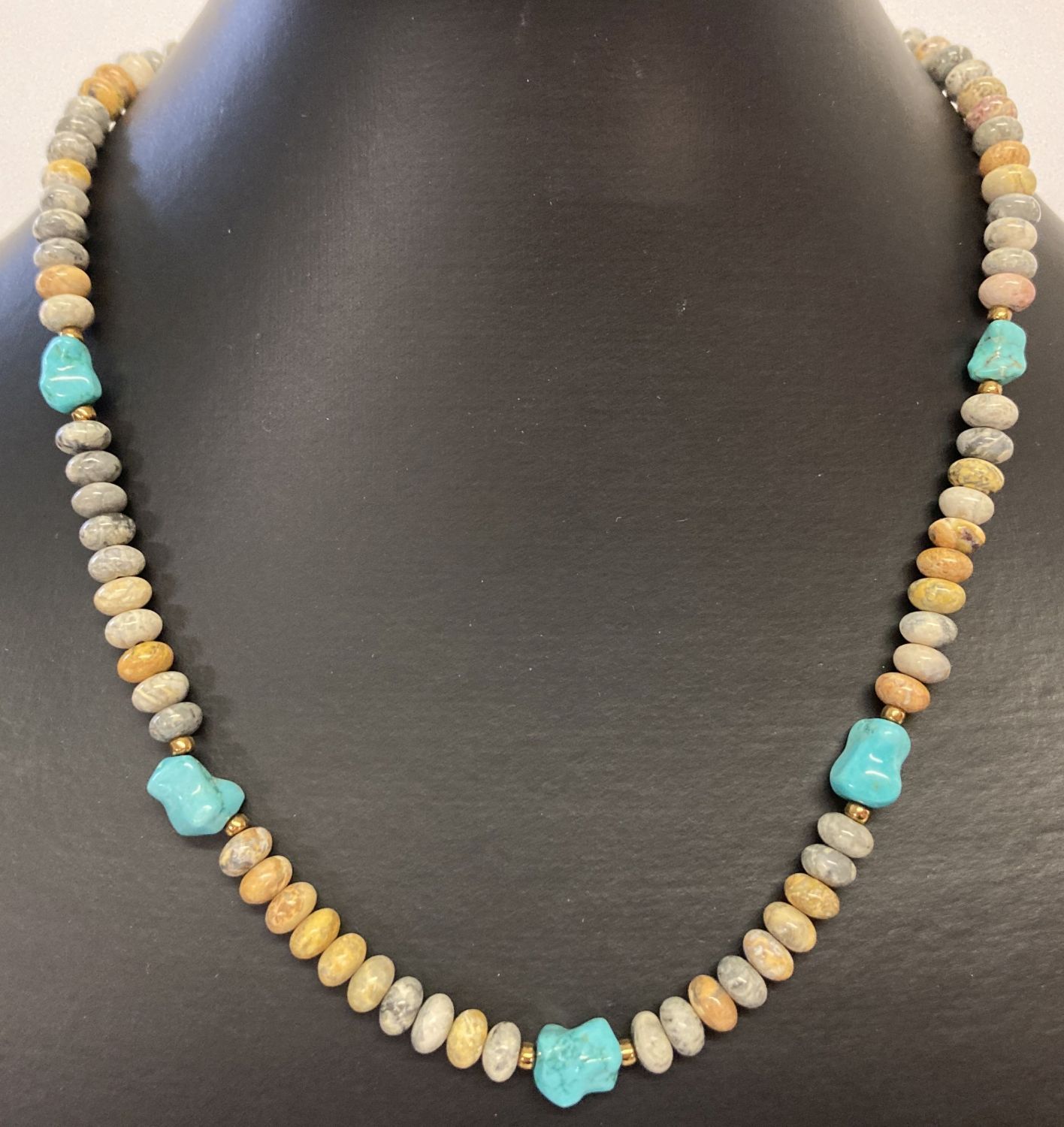 A 17" leopard skin jasper and turquoise beaded necklace with gold tone T bar clasp.