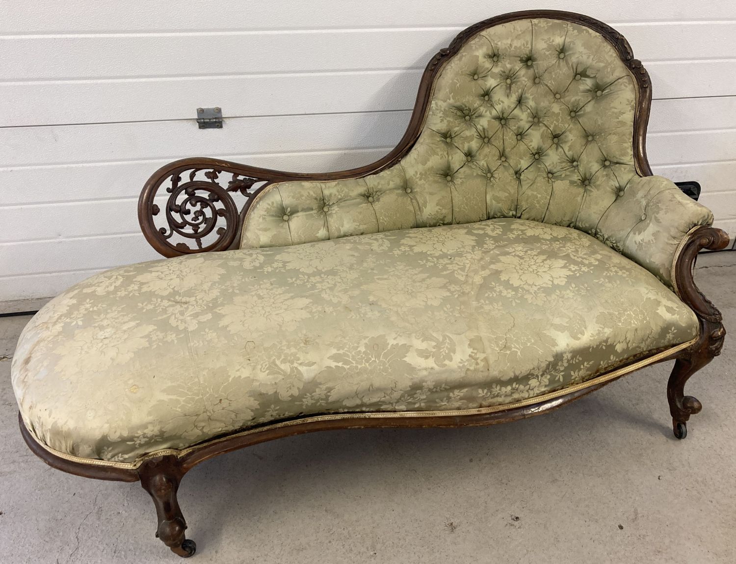 A Victorian walnut framed chaise lounge with green damask style upholstery and button back detail.