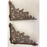A pair of rust effect cast metal wall shelf bracelets, with decorative scroll & leaf design.