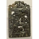 An ornately carved dark jade rectangular panel shaped pendant with mythical creature design.