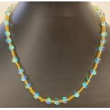 A 15" yellow glass and turquoise Austrian crystal beaded necklace with gold tone magnetic clasp.