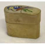 A small gilt metal pill box with shell lid and painted bird decoration.
