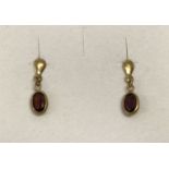 A small pair of 9ct gold and garnet set drop style earrings.