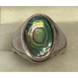 A men's silver signet ring set with an oval of paua shell. Marked 925 to inside of band.