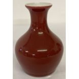 A small Chinese ceramic vase of bulbous form with red/brown glaze.