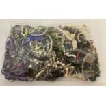 A sealed bag of mixed modern costume jewellery to include faux pearl bracelets and beaded necklaces.